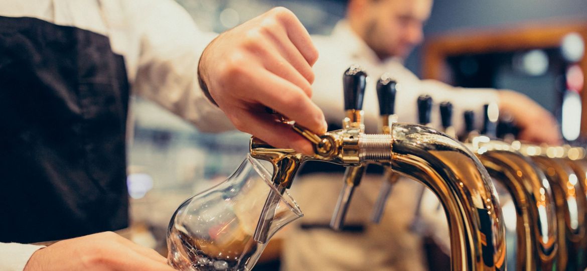 Two handsome bartenders poring beer at pub